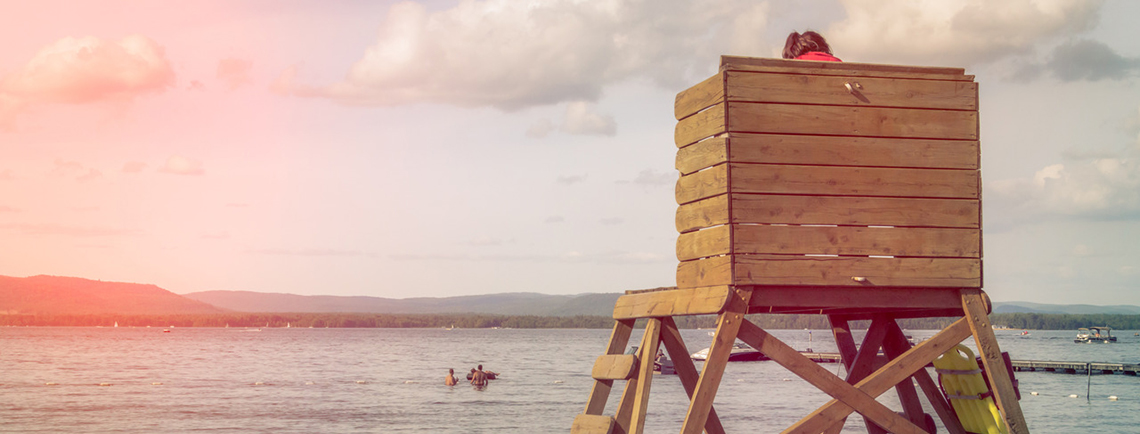 Lifeguard on stand watching over swimmers at the beach